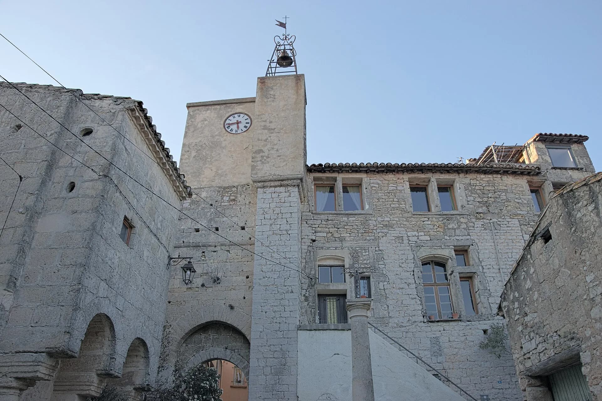 Le clocher à horloge et les arcades de pierre, à Cournonsec