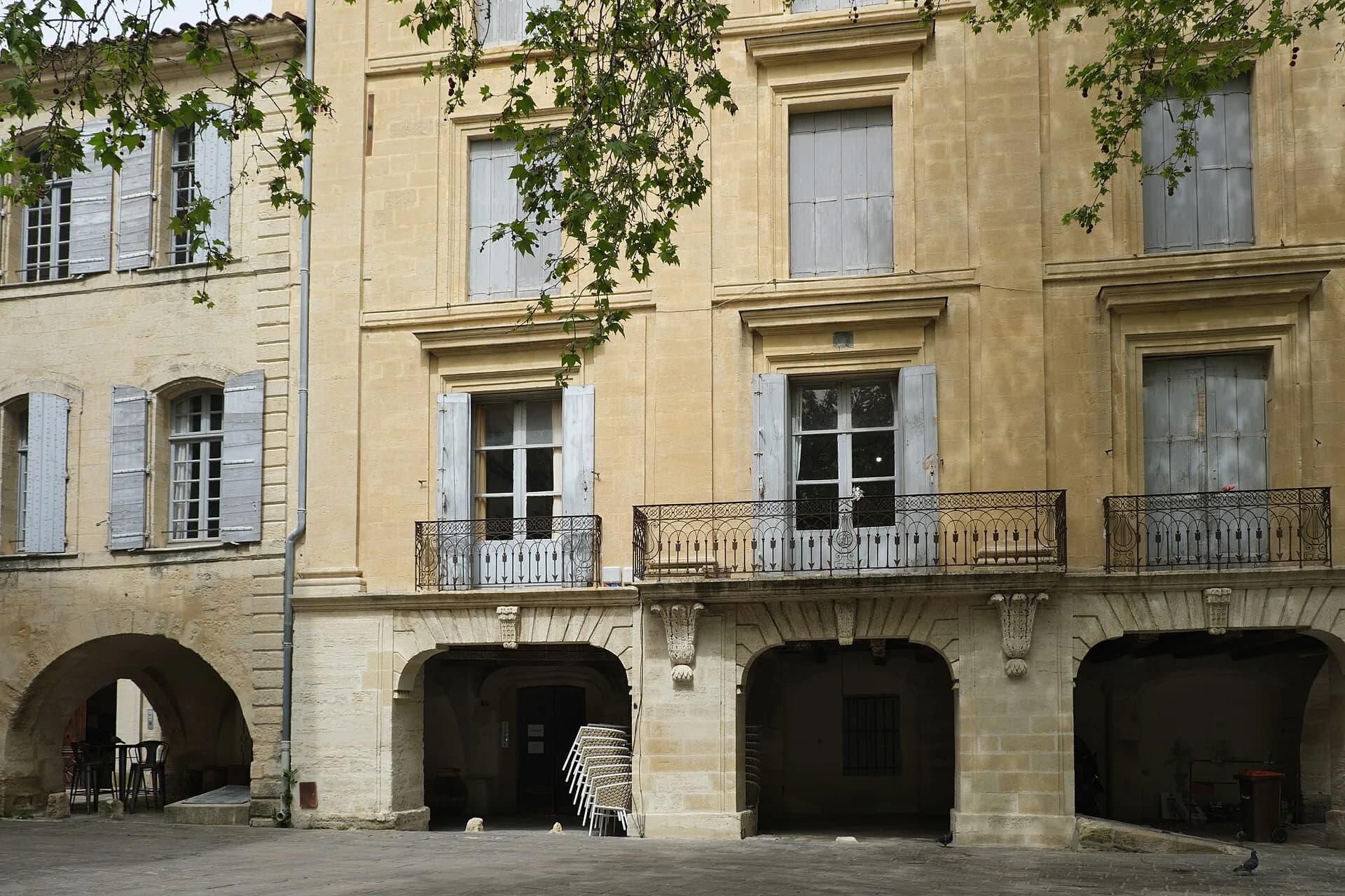 Les arcades et les façades en pierre de la place aux Herbes, à Uzès
