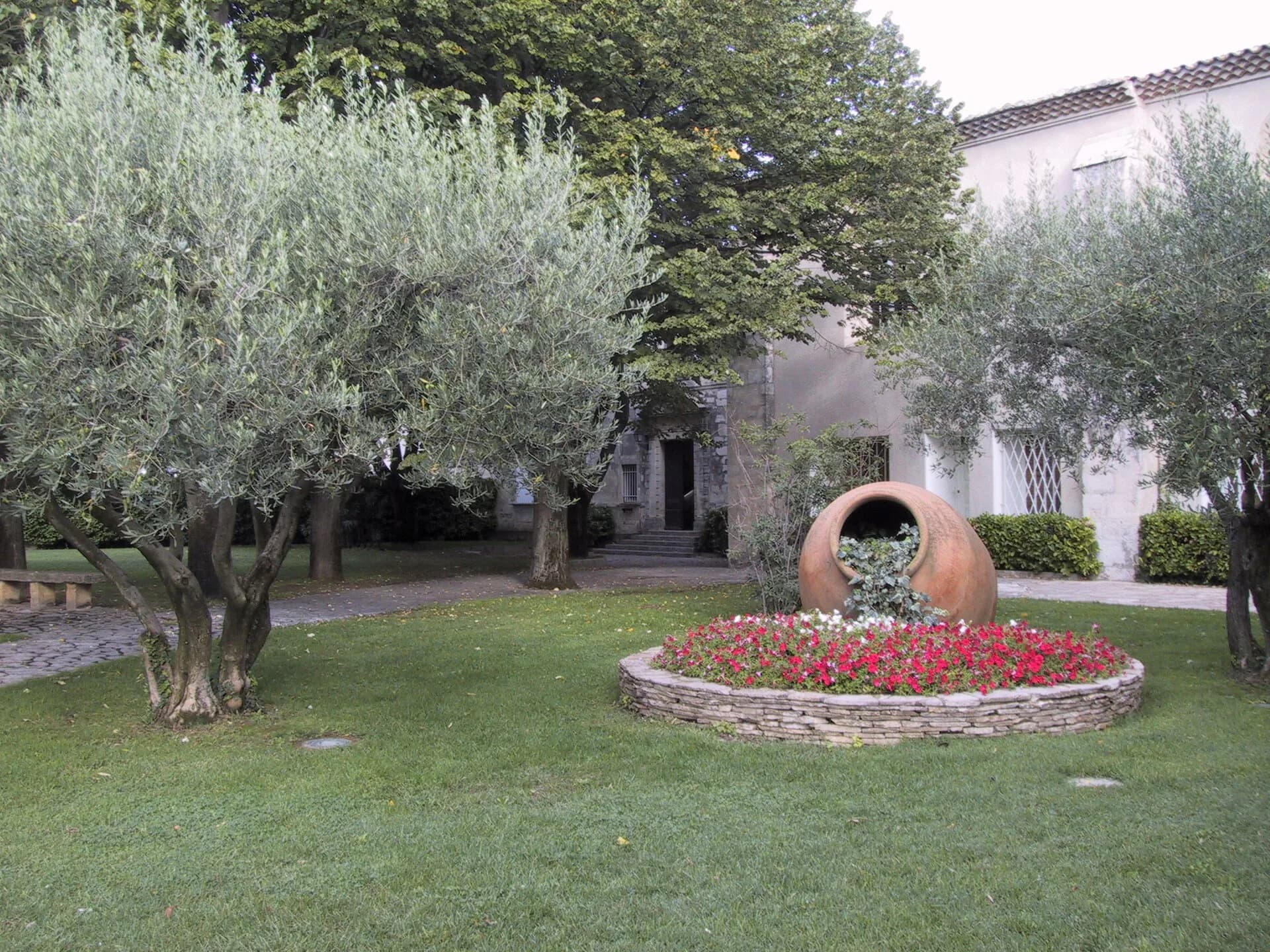 Le jardin de la mairie de Garons, ses oliviers, sa jarre en terre cuite et son massif de pierre sèche