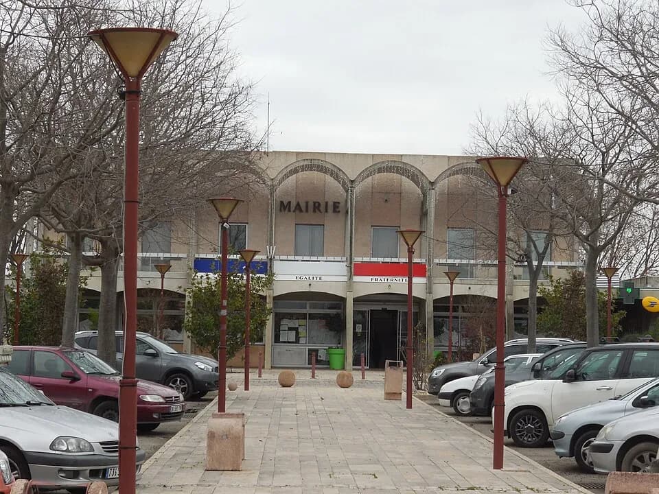 La mairie de Rodilhan, ses arcades de pierre claire et la place plantee de platanes
