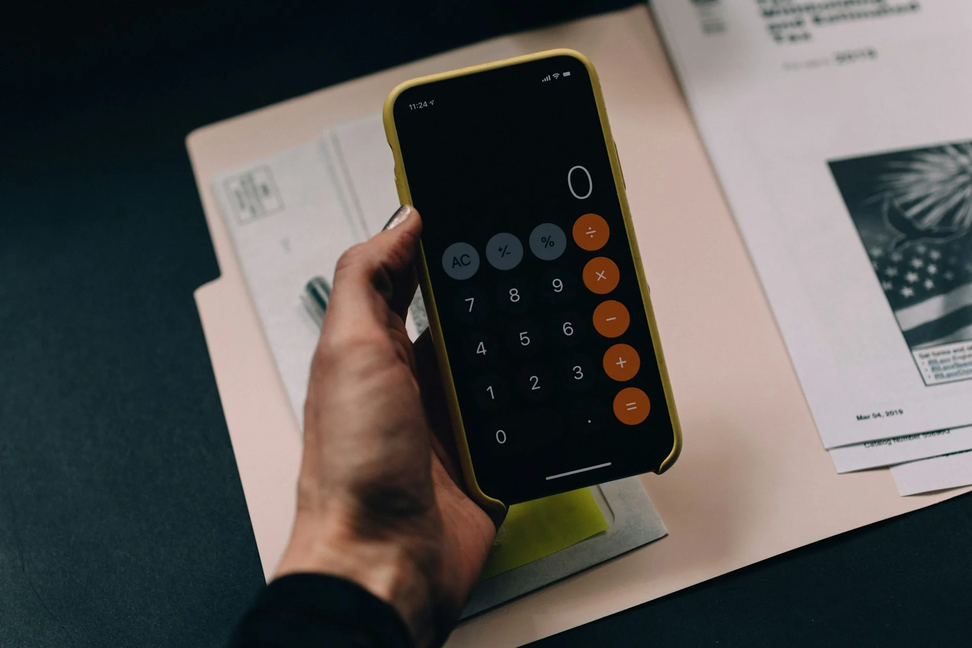 Une calculatrice ouverte sur un téléphone, posée sur un dossier